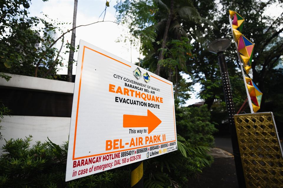 A barangay sign reading Earthquake Evacuation Route, with an arrow pointing the way to Bel-Air Park II