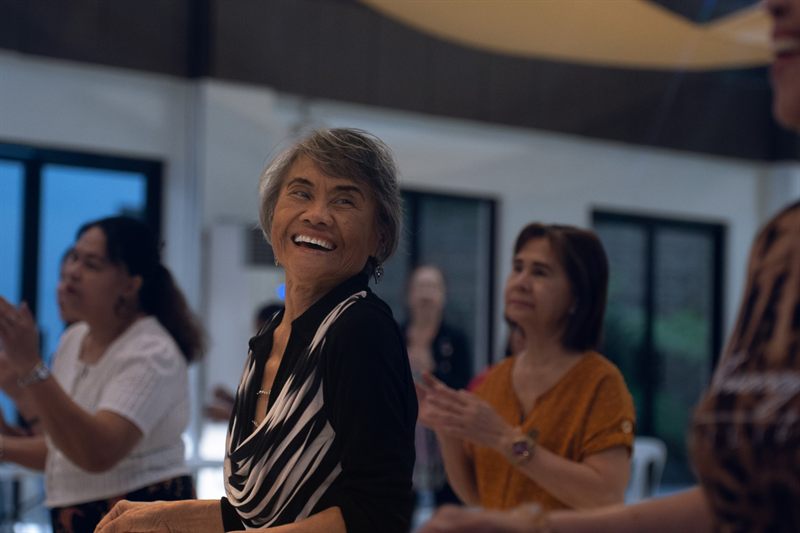 A smiling senior resident at a community gathering